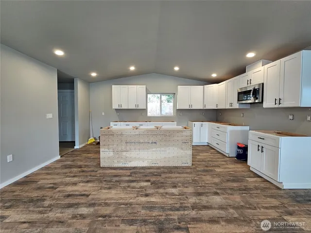 a large kitchen with stainless steel appliances granite countertop a stove and a sink