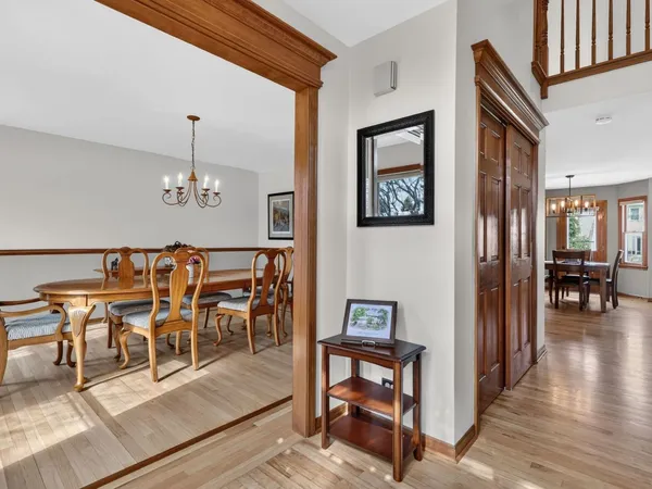 a kitchen with stainless steel appliances granite countertop a stove top oven a sink dishwasher a dining table and chairs cabinets with wooden floor
