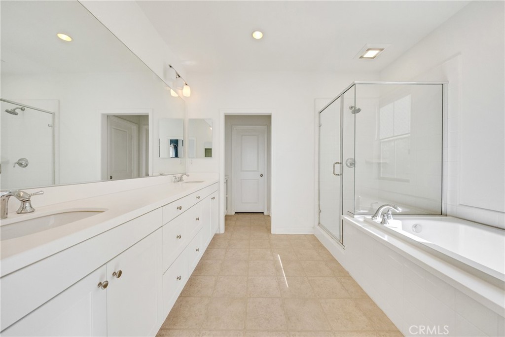 107 Hanging Garden Irvine, CA 92620 - Photo 18 of 26 a spacious bathroom with a double vanity sink shower and a bathtub