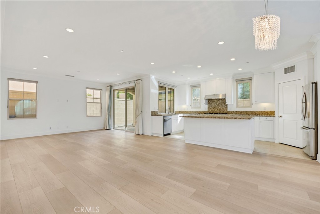 107 Hanging Garden Irvine, CA 92620 - Photo 10 of 26 a view of kitchen with kitchen island white cabinets and refrigerator