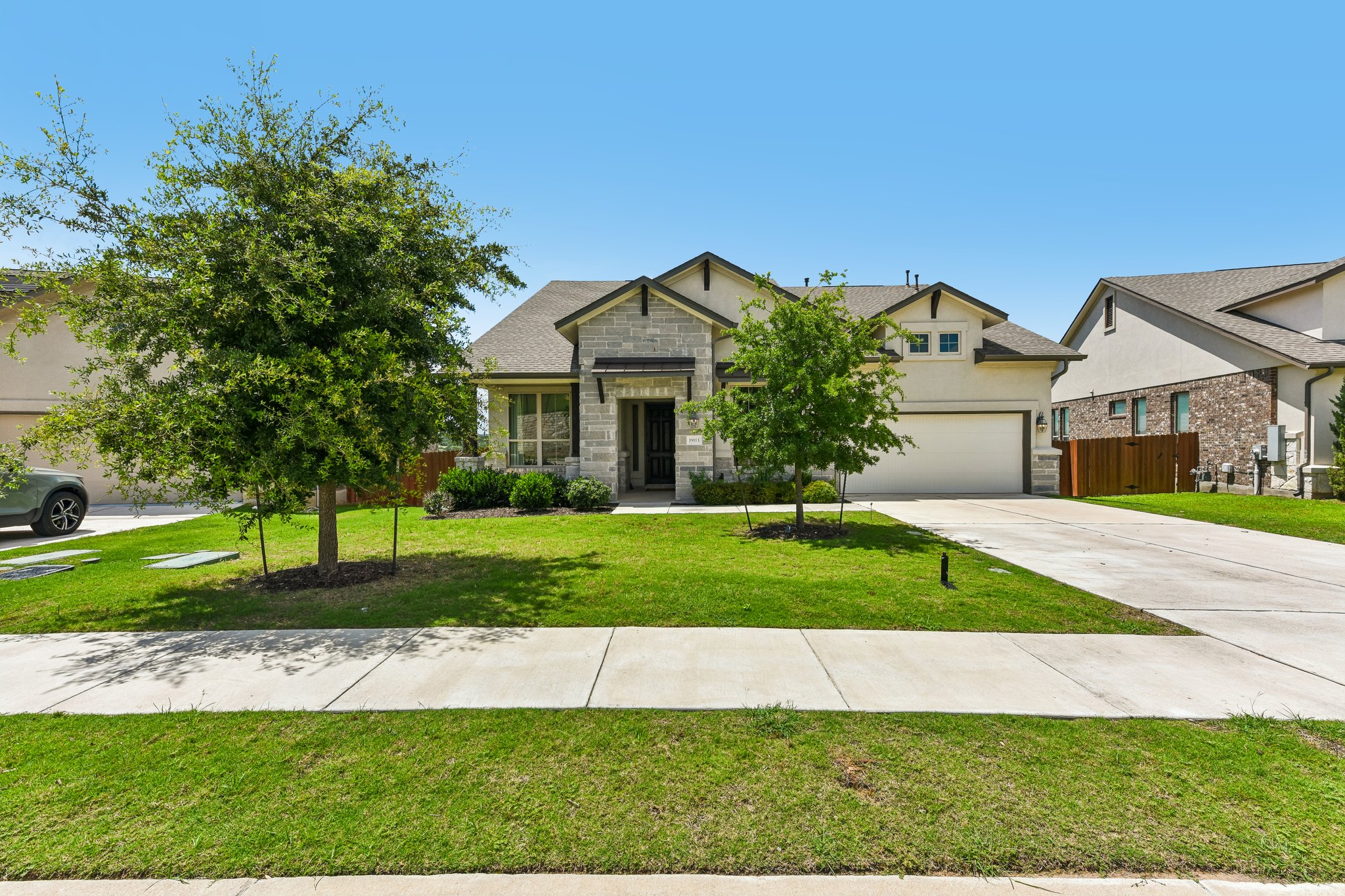 19113 Freeman Circle Austin, TX 78738 - Photo 2 of 37 A well-maintained lawn and mature trees frame this inviting suburban residence.