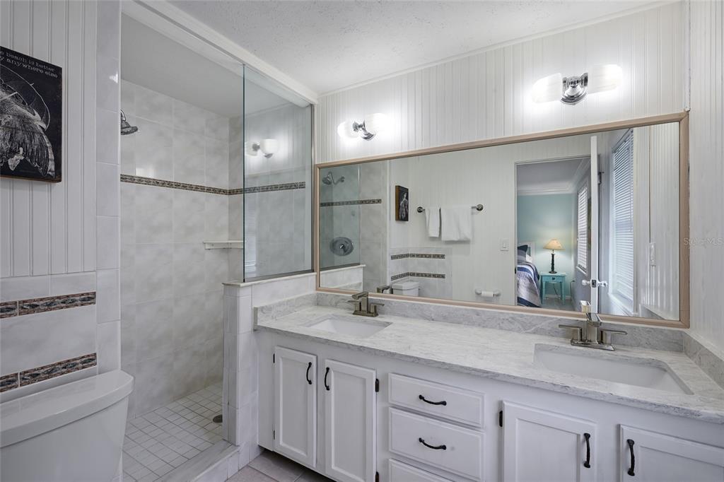 120 Maple Avenue Anna Maria, FL 34216 - Photo 18 of 39 a bathroom with a granite countertop sink a toilet and a mirror