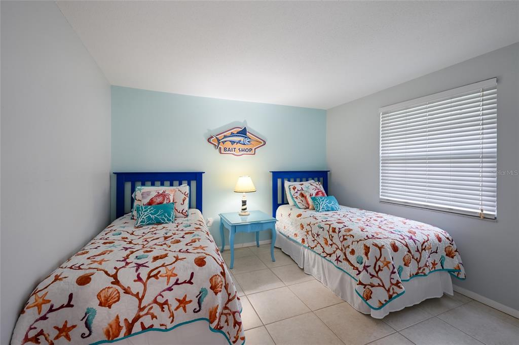 120 Maple Avenue Anna Maria, FL 34216 - Photo 21 of 39 a bedroom with two beds and a window
