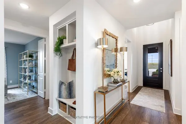 a kitchen with stainless steel appliances granite countertop a refrigerator and a wooden floor