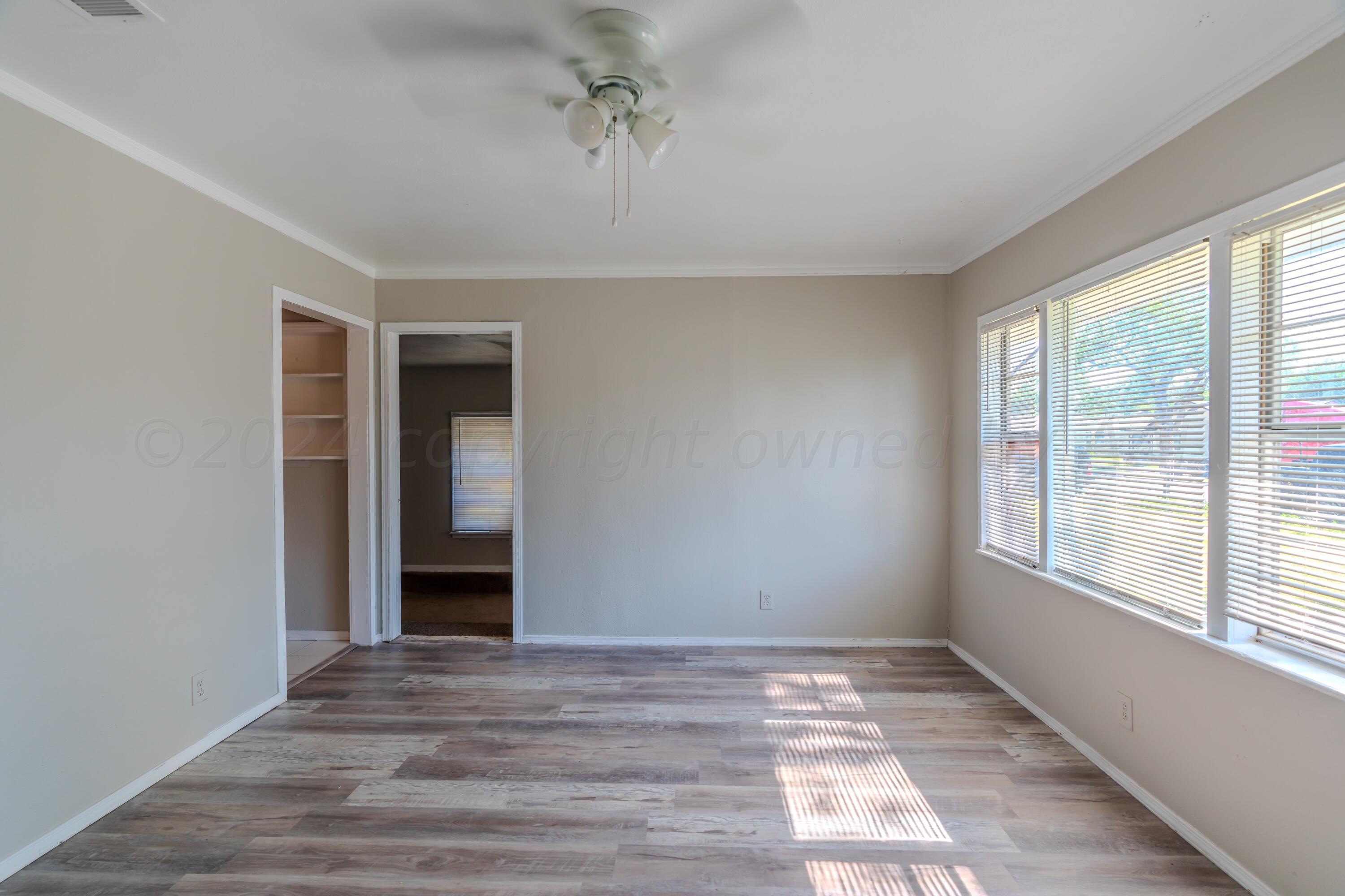 4116 Gables Street Amarillo, TX 79110 - Photo 2 of 13 a view of an empty room with wooden floor and a window