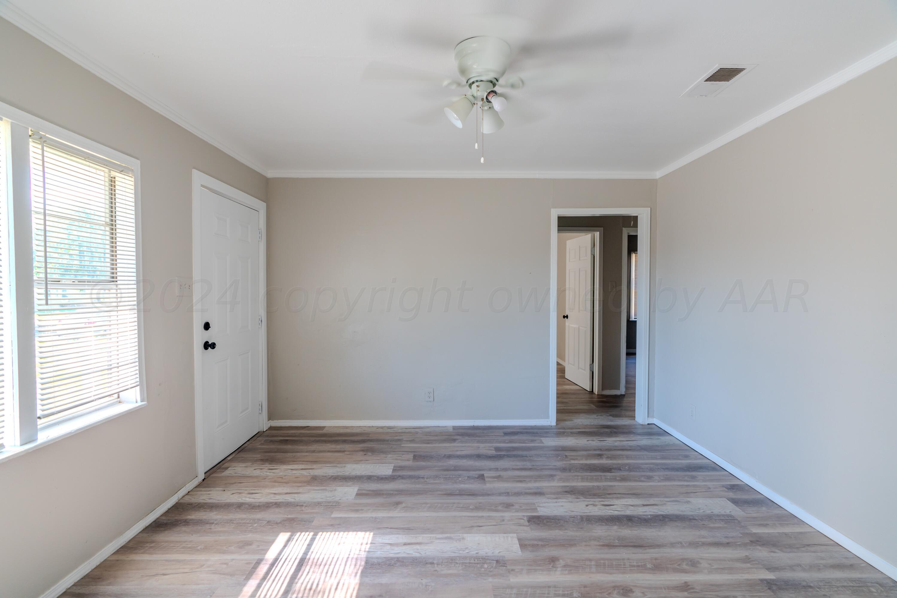 4116 Gables Street Amarillo, TX 79110 - Photo 3 of 13 a view of an empty room with wooden floor and a window