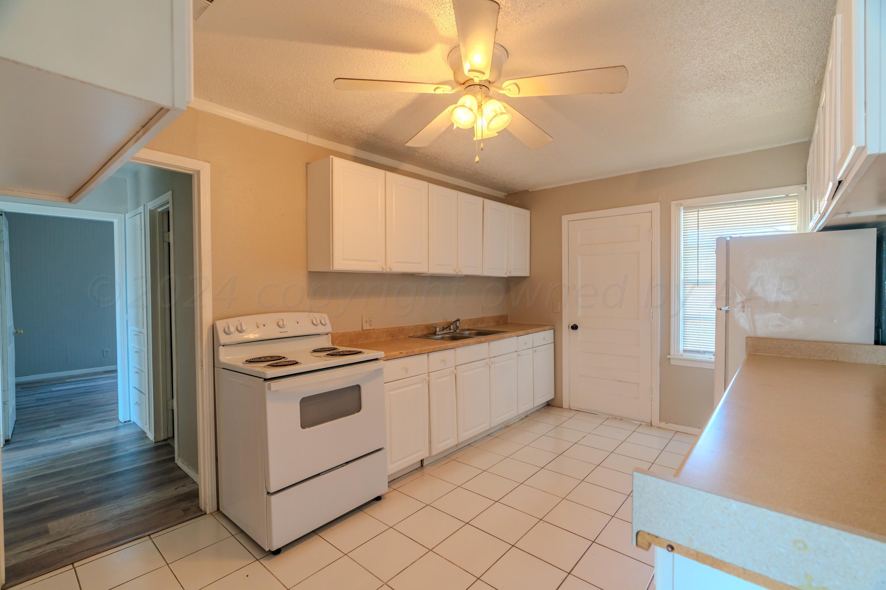 4116 Gables Street Amarillo, TX 79110 - Photo 4 of 13 a kitchen with a stove a sink and a refrigerator