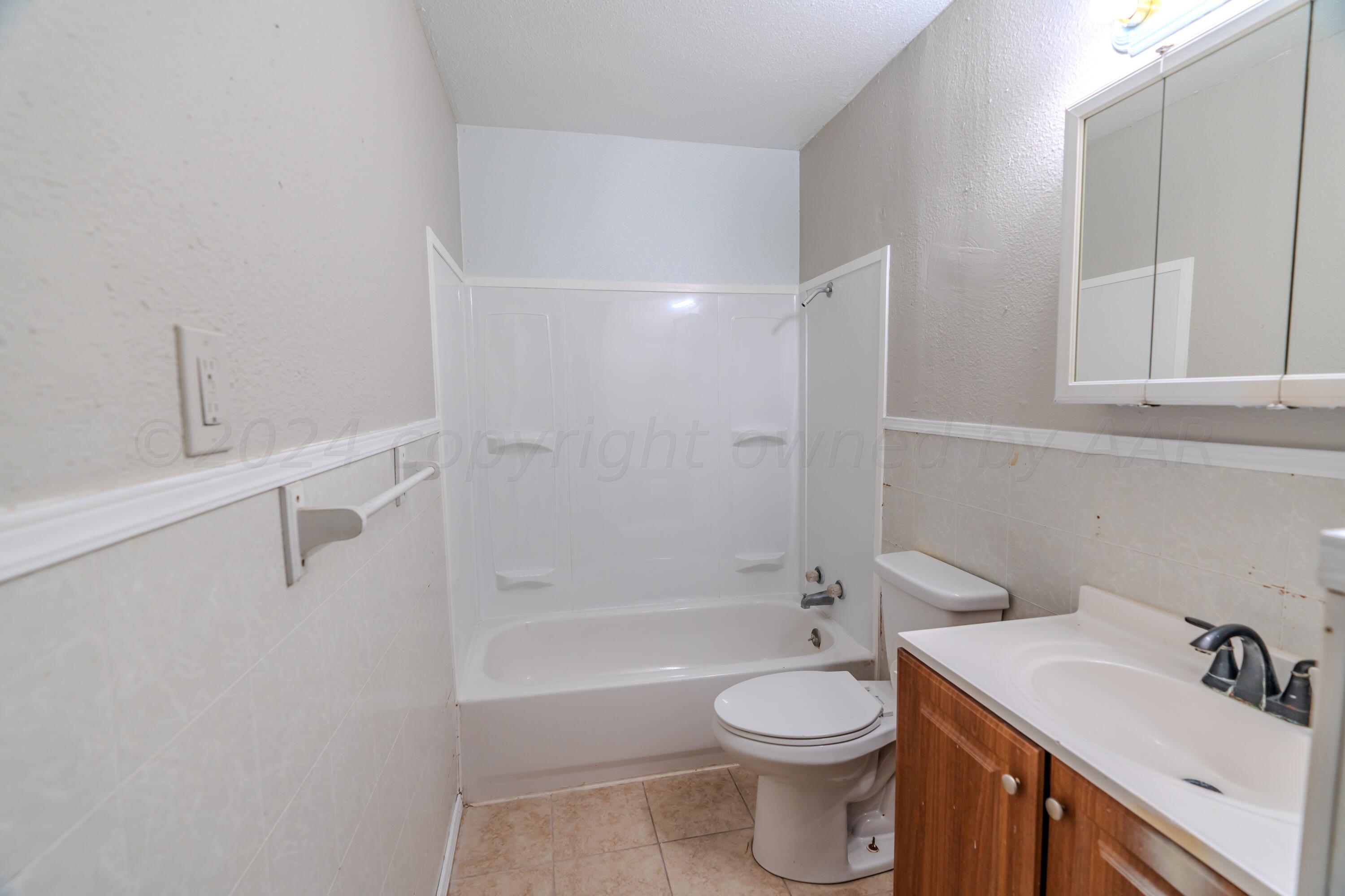 4116 Gables Street Amarillo, TX 79110 - Photo 8 of 13 a bathroom with a sink a toilet and shower
