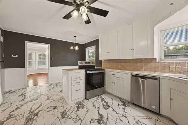 a kitchen with white cabinets and appliances
