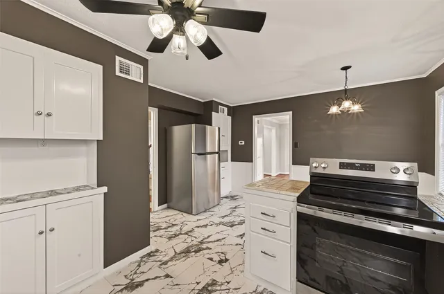 a kitchen with stainless steel appliances kitchen island granite countertop a stove and a refrigerator