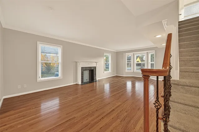 a view of empty room with fireplace and wooden floor
