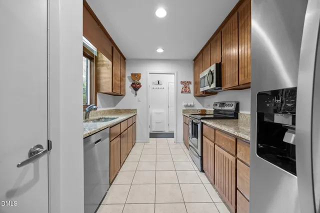 a large kitchen with stainless steel appliances granite countertop a large stove top oven a sink and dishwasher