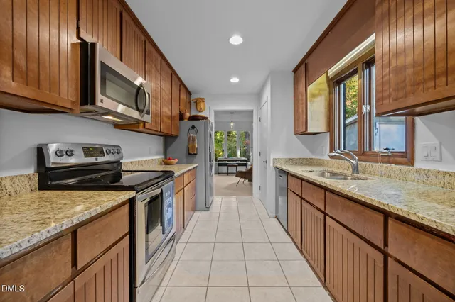 a kitchen with stainless steel appliances granite countertop a stove a sink and a microwave