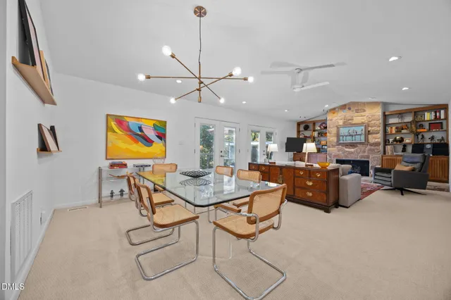 a living room with furniture kitchen view and a chandelier