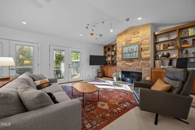 a living room with fireplace furniture and a large window