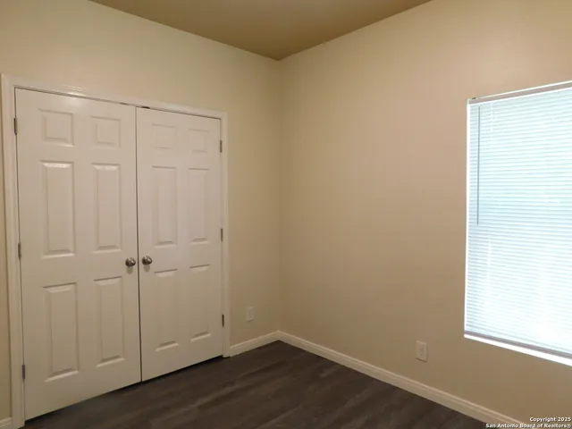 an empty room with wooden floor and closet