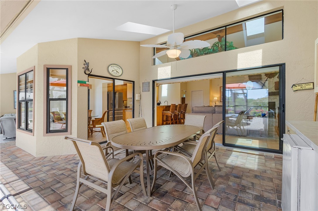 7747 Grande Pine Road Bokeelia, FL 33922 - Photo 33 of 45 a dining room with furniture a chandelier and fireplace