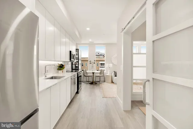 a kitchen with white cabinets and sink