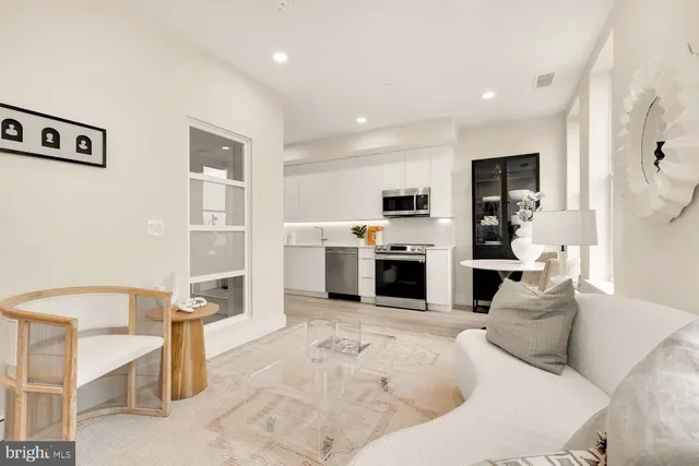 a living room with furniture a kitchen view and a fireplace