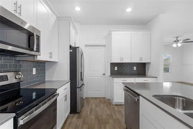 a kitchen with a sink and steel appliances
