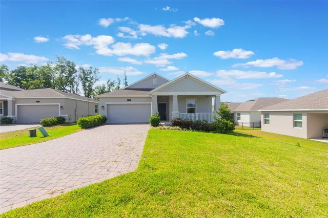 a view of a house with a backyard and a tree