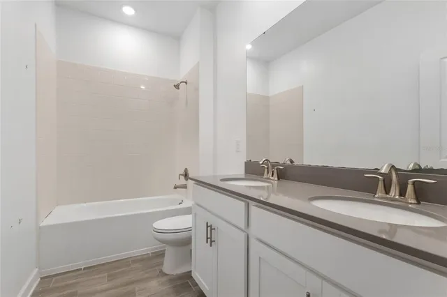 a bathroom with a granite countertop sink a toilet and a bathtub