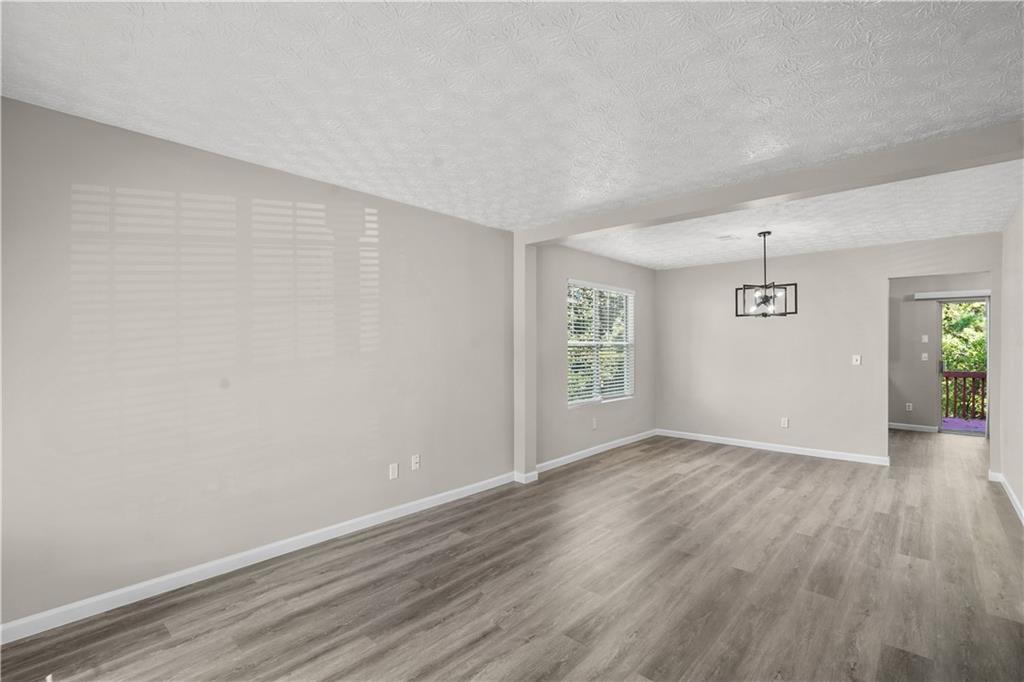 826 Shore Drive Lithonia, GA 30058 - Photo 18 of 42 an empty room with wooden floor and windows