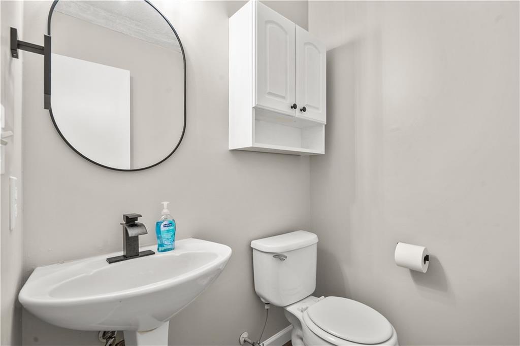 826 Shore Drive Lithonia, GA 30058 - Photo 22 of 42 a white toilet sitting next to a bathroom sink