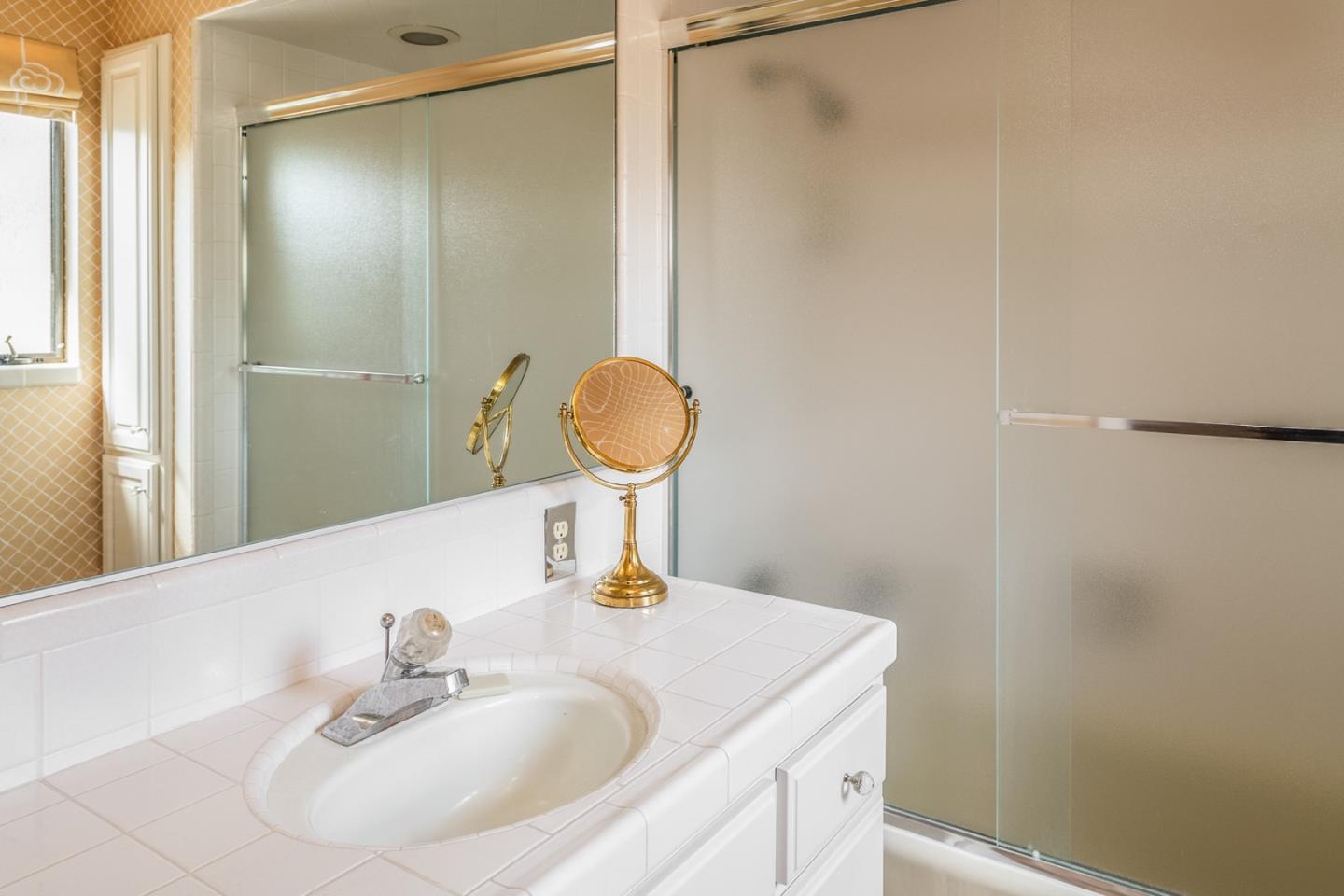 1020 Rodeo Road Pebble Beach, CA 93953 - Photo 15 of 38 a bathroom with a sink and a mirror