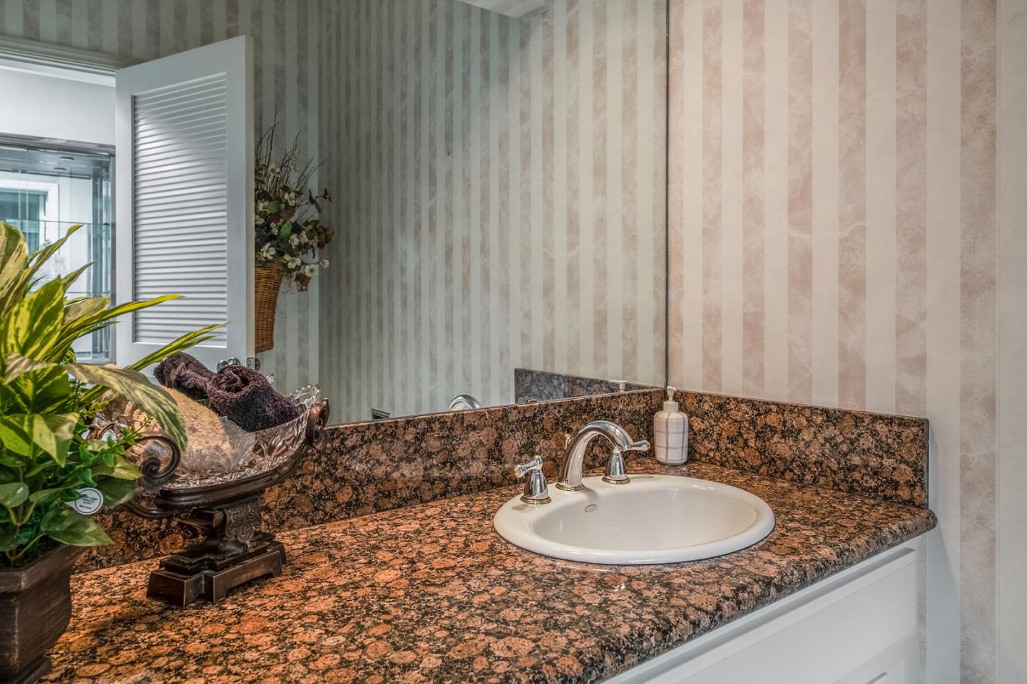 1020 Rodeo Road Pebble Beach, CA 93953 - Photo 31 of 38 a bathroom with a granite countertop sink and a mirror