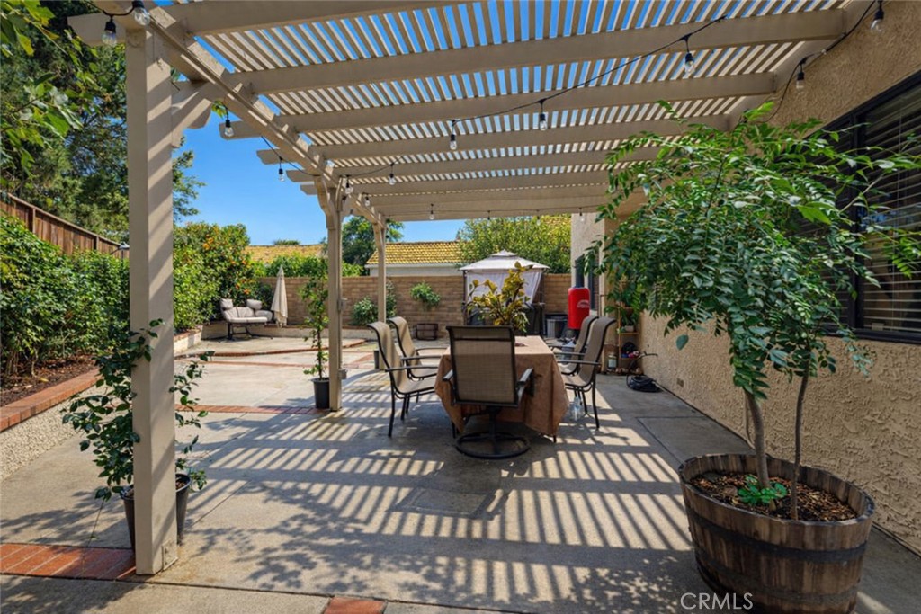 2124 Snowberry Court Simi Valley, CA 93063 - Photo 20 of 23 a view of a patio with table and chairs potted plants and large tree