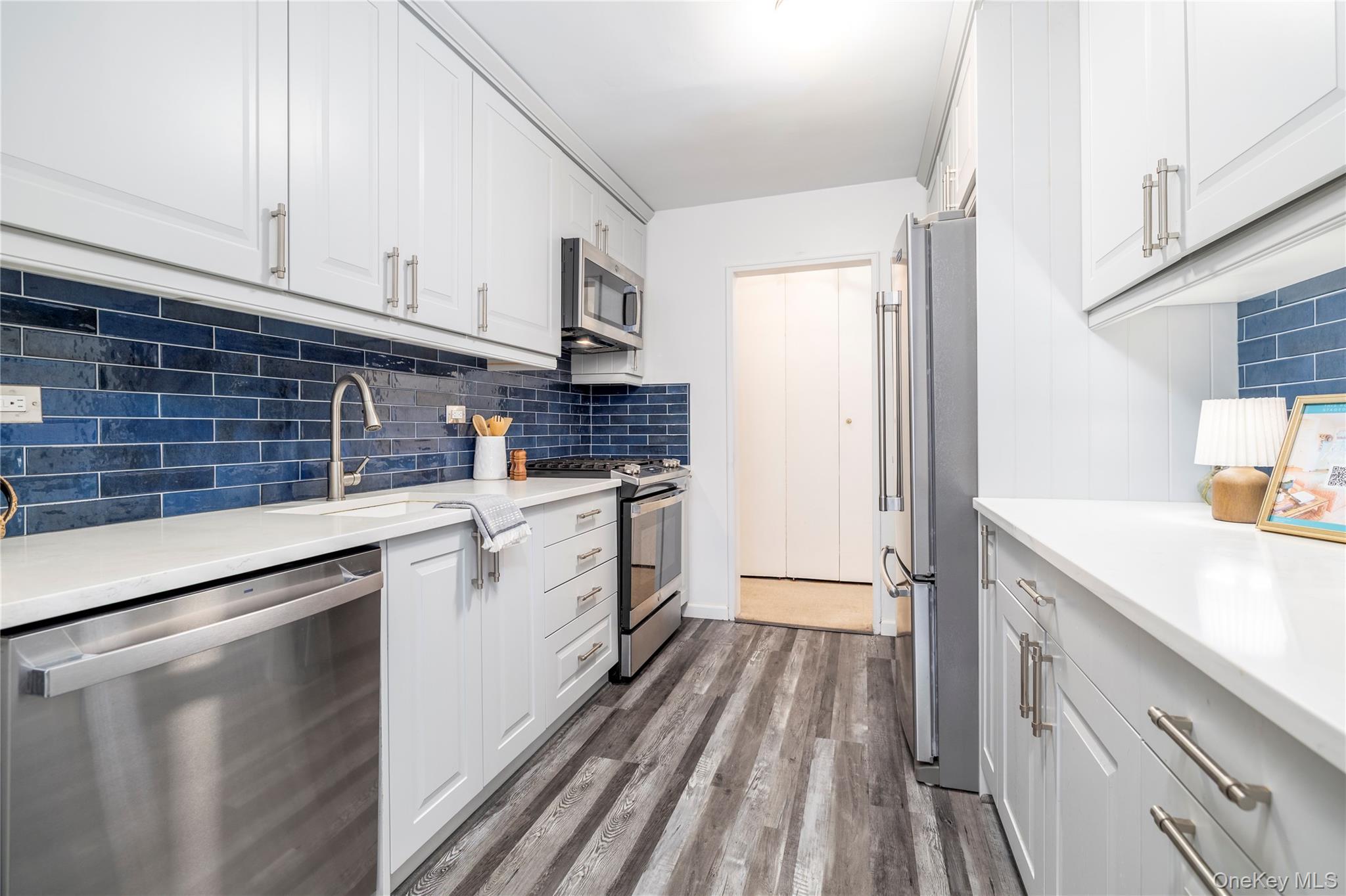 522 Shore Road, Unit 6C Long Beach, NY 11561 - Photo 10 of 25 a kitchen with a sink stove and cabinets