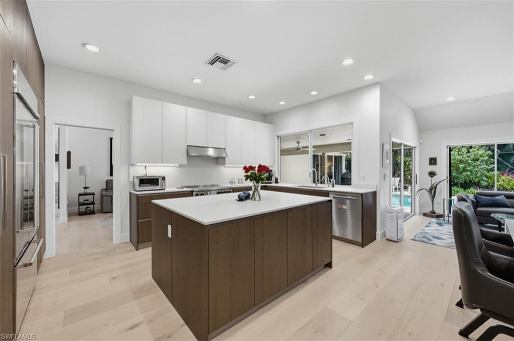 512 Turtle Hatch Road Naples, FL 34103 - Photo 7 of 18 Custom cabinetry highlighted by quartz counters, premium gas range, & Sub-Zero refrigerator/freezer