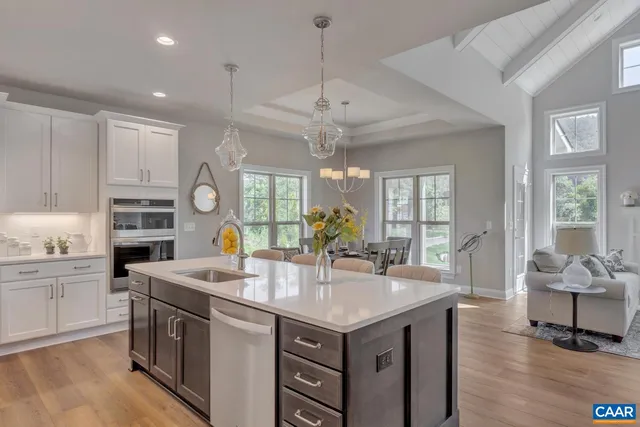a dining room with furniture a chandelier and wooden floor