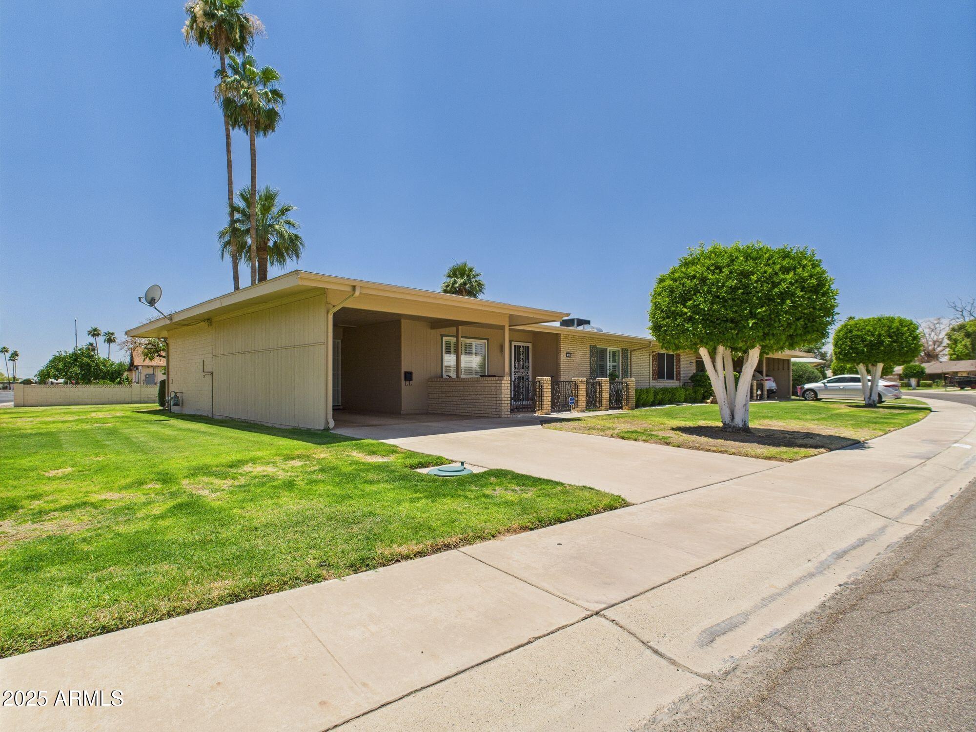9915 West Mountain View Road Sun City, AZ 85351 - Photo 1 of 22 a front view of a house with garden