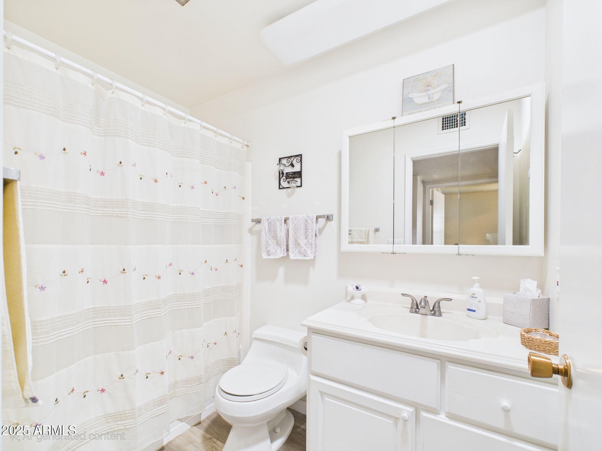9915 West Mountain View Road Sun City, AZ 85351 - Photo 11 of 22 a bathroom with a sink toilet vanity and shower