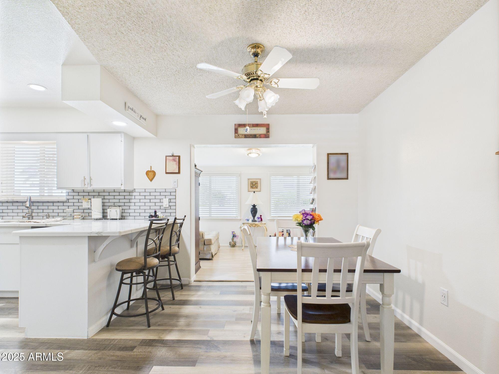 9915 West Mountain View Road Sun City, AZ 85351 - Photo 8 of 22 a view of a dining room with furniture and a chandelier