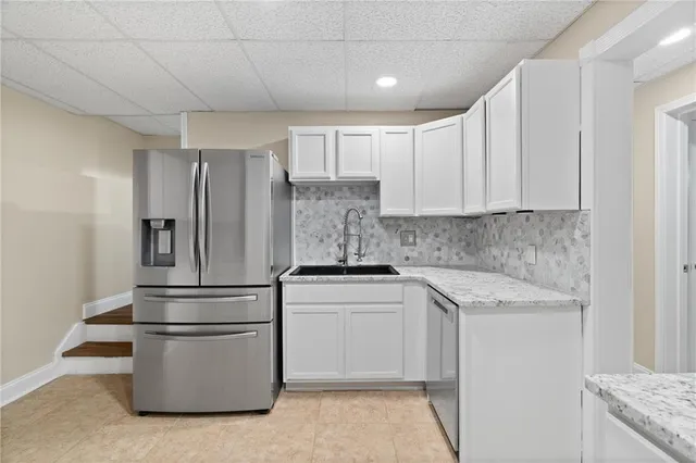 a spacious bedroom with a large bed a flat screen tv and a couch