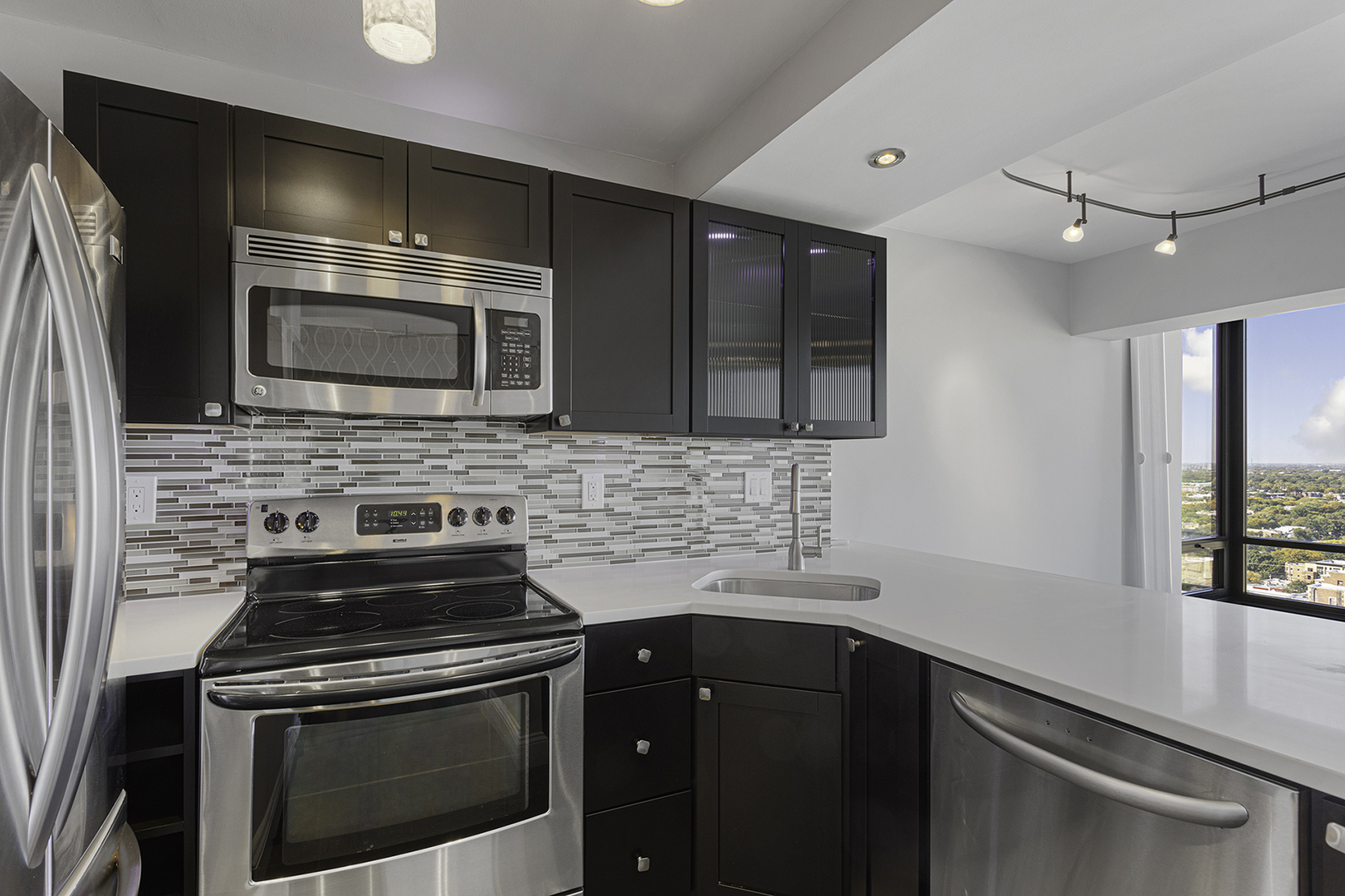 6166 North Sheridan Road, Unit 24L Chicago, IL 60660 - Photo 5 of 18 a kitchen with stainless steel appliances a stove microwave and cabinets
