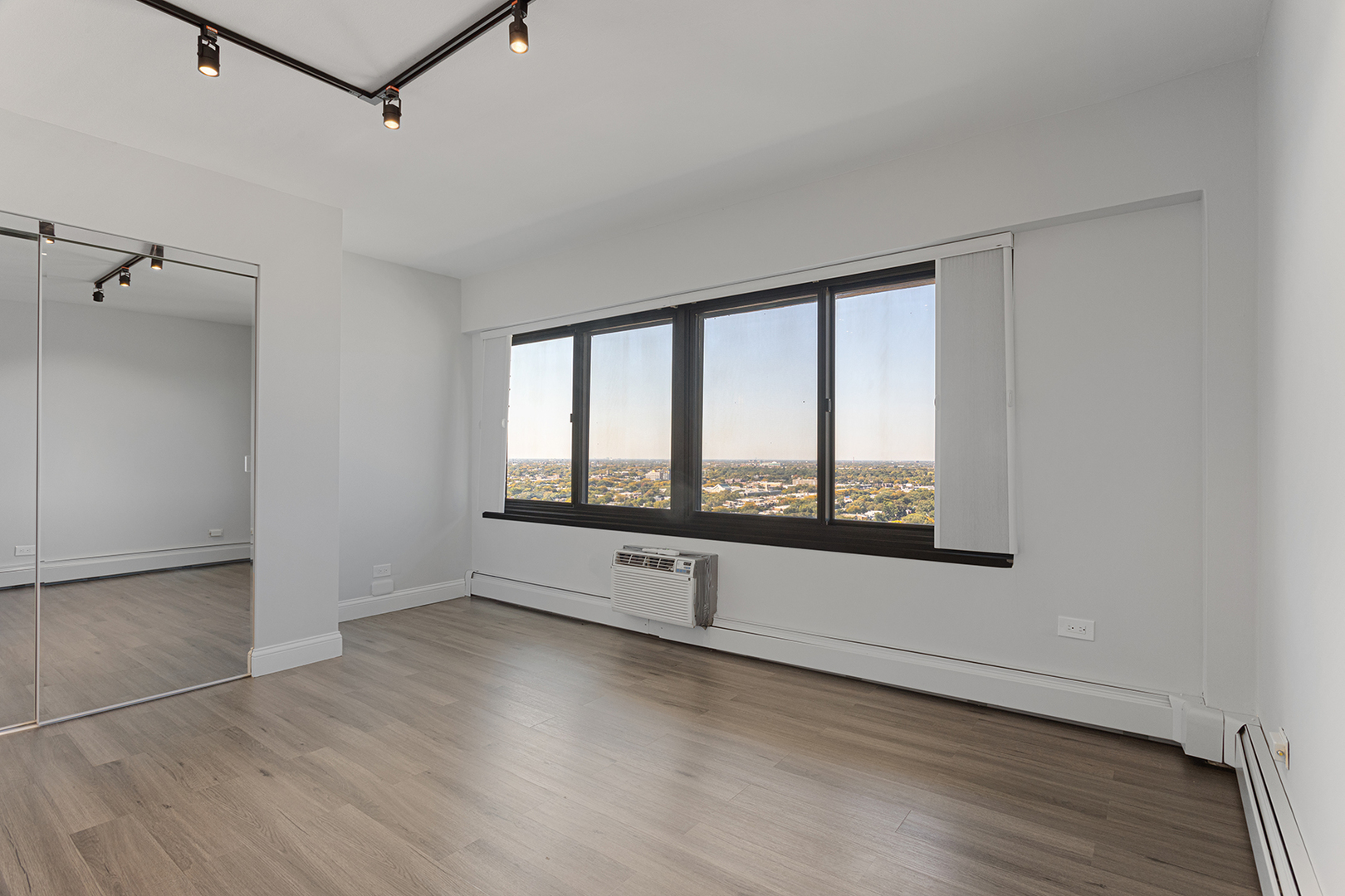 6166 North Sheridan Road, Unit 24L Chicago, IL 60660 - Photo 7 of 18 an empty room with wooden floor and windows
