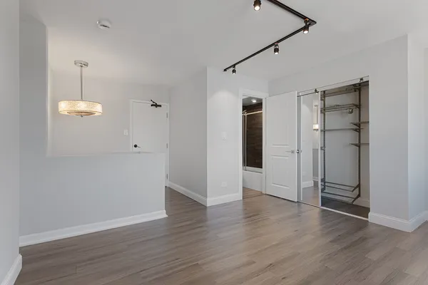an empty room with wooden floor and window