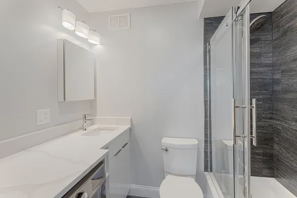 a bathroom with a sink a toilet and shower