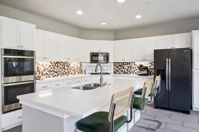 a kitchen with a sink a refrigerator and a stove top oven