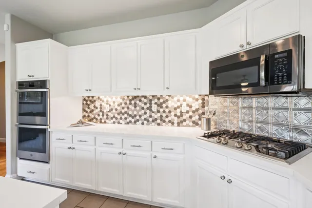 a kitchen with granite countertop cabinets and steel stove