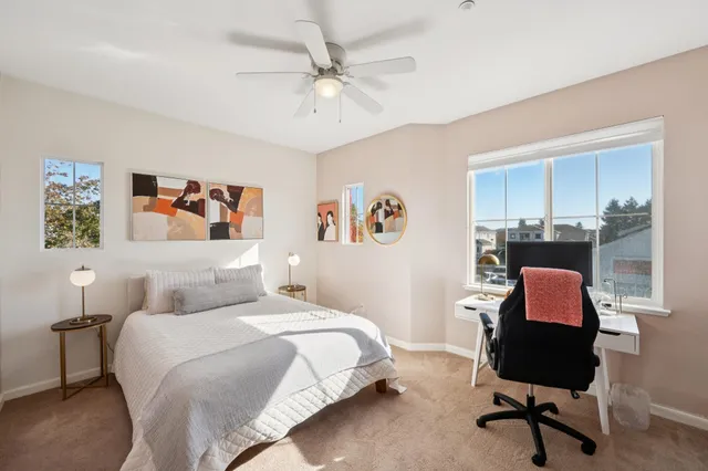 a bedroom with a bed a desk and chair with a bookshelf