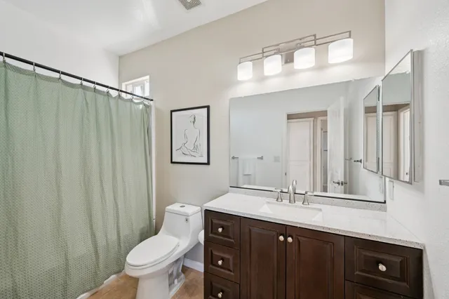 a bathroom with a double vanity sink toilet and a mirror