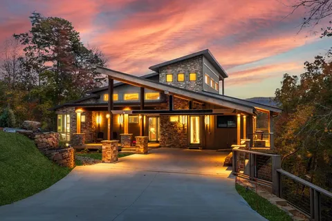 a front view of house with yard and trees in the background