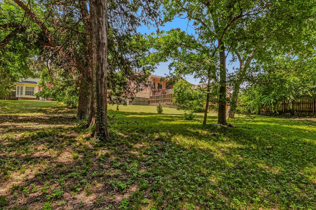 9301 Nottingham Court Rowlett, TX 75088 - Photo 36 of 39 Expansive yard featuring mature trees, a gently sloping lawn, and perimeter fencing