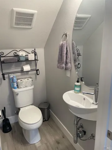 a bathroom with a sink a toilet and mirror