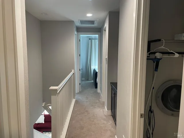 a view of a hallway with closet and bathroom